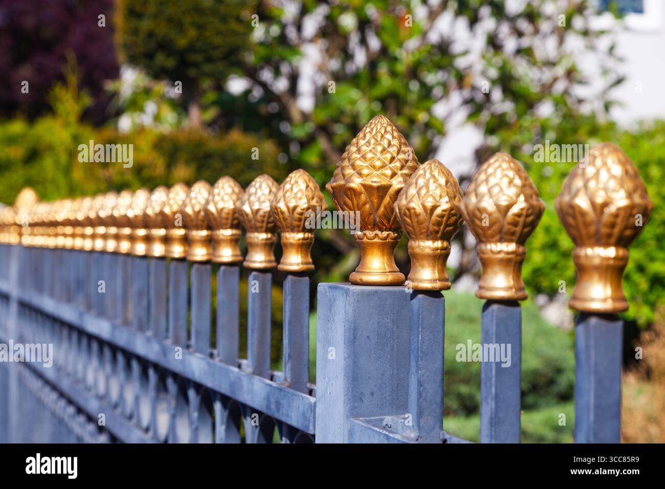 Clôture en acier avec des pointes décoratives en bronze dessus. Banque D'Images