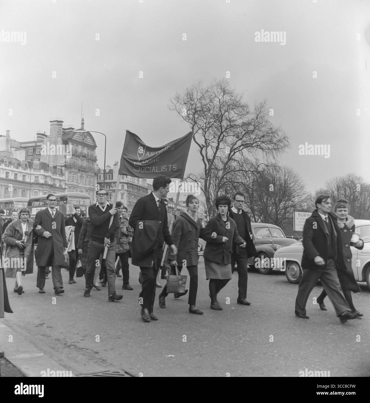 Une photographie en noir et blanc prise lors d'un rassemblement de la CND, Campaign for Nuclear Disarmament, à Londres en 1963. Deux personnes portent une bannière Hastings Young Socialists, Banque D'Images