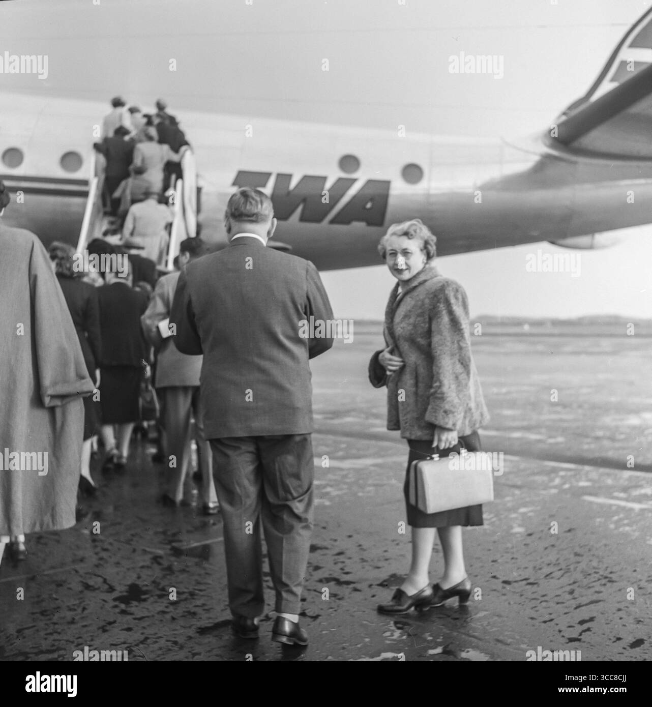 Vintage 1952 photographie noir et blanc montrant un groupe de personnes sur le point d'embarquer à bord d'un avion TWA, TRANS World Airlines, Lockheed Constellation. Banque D'Images