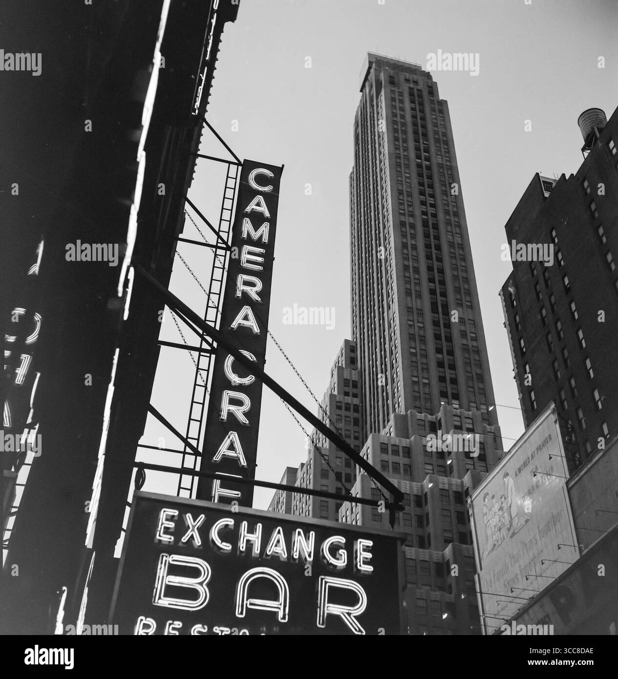 Une photographie vintage en noir et blanc de 1952 regardant des bâtiments et des panneaux à New York, aux États-Unis. Banque D'Images