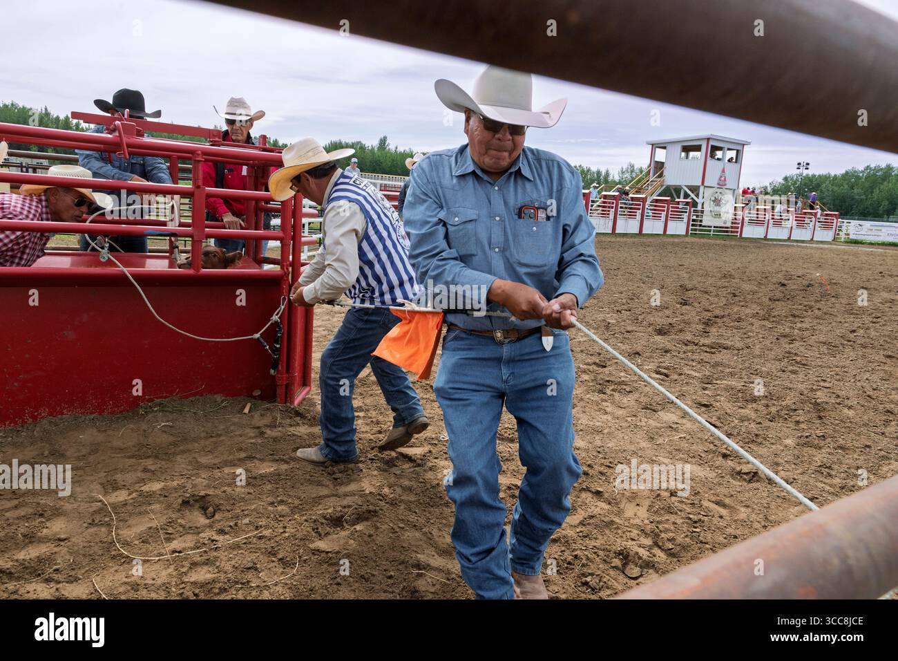 Des cow-boys préparant une corde de barrière pour un événement de corde de veau à un rodéo indien à Enoch Alberta Canada Banque D'Images