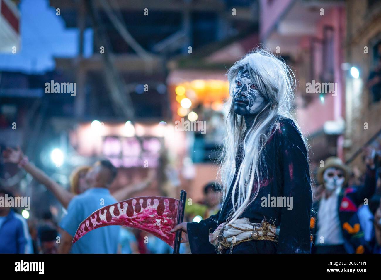 Un homme au visage peint est vu pendant le Gai Jatra ou la procession du festival des vaches. Les gens célèbrent Gai Jatra ou fête de la vache en mémoire des âmes disparues au cours de l'année écoulée pour le salut et la paix. On croit que les vaches guident les âmes défuntes à traverser la rivière pour se rendre au ciel. Banque D'Images