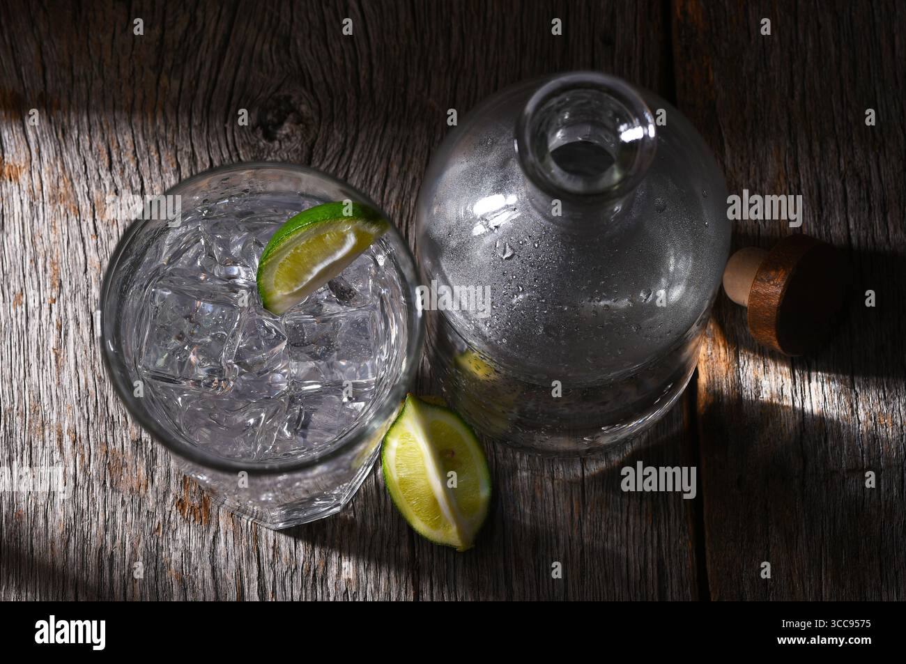 Bouteille d'eau et verre avec tranche de citron vert. Prise de vue en grand angle. Banque D'Images