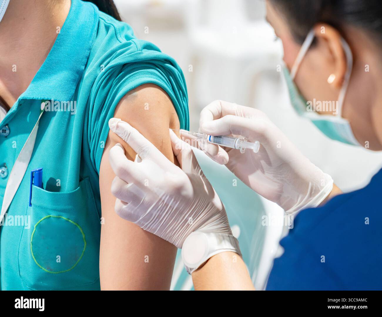 Travailleur qui administre une injection de vaccin à un patient Banque D'Images