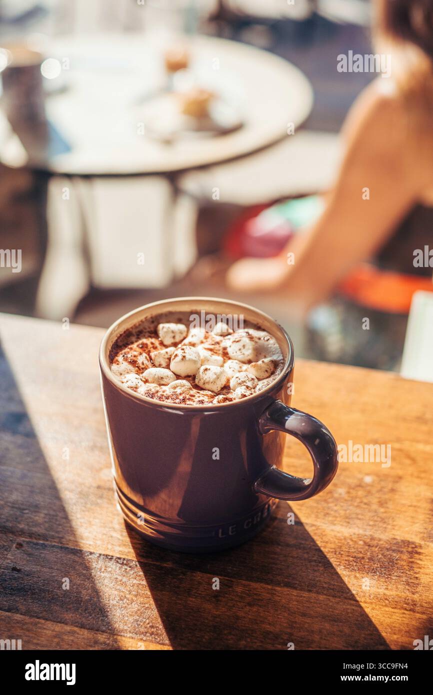 Chocolat chaud avec guimauves au café ensoleillé Banque D'Images