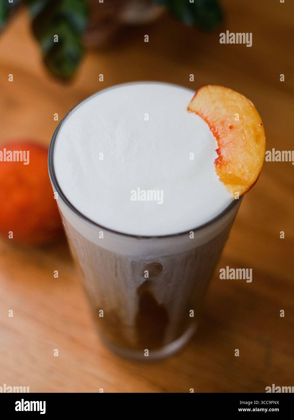 Café en mousse froide à la pêche dans un grand verre (gros plan) Banque D'Images