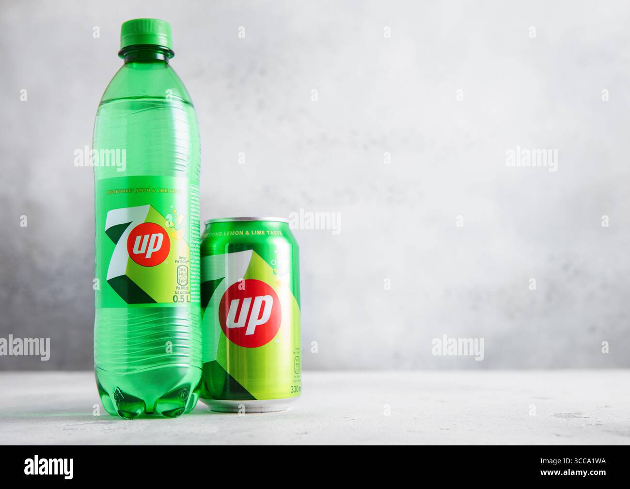 LONDRES, Royaume-Uni - 15 JUILLET 2025 : bouteille et boîte en aluminium de boisson gazeuse au citron vert et au citron 7UP sur table lumineuse. Banque D'Images