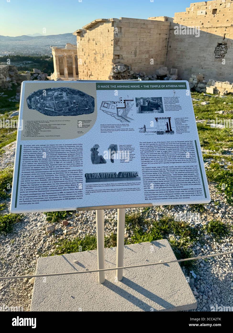 Plaque d'information détaillant le temple d'Athéna sur l'Acropole à Athènes, Grèce, avec pour toile de fond des ruines antiques et un ciel clair. Banque D'Images