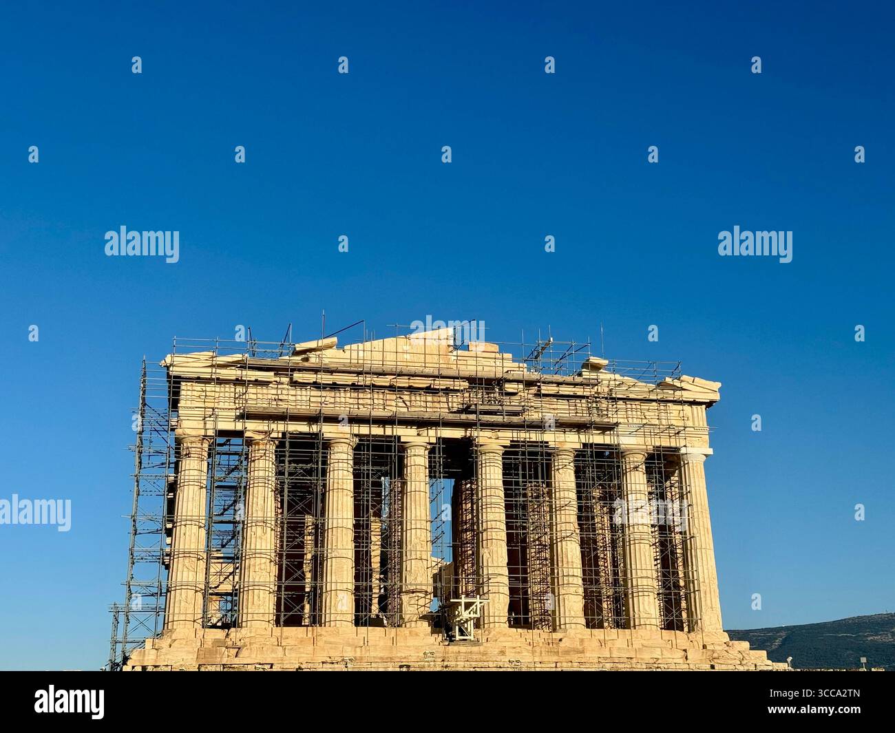 Le Parthénon sur l'Acropole d'Athènes en cours de restauration, avec une plaque informative au premier plan détaillant son histoire et son architecture. Banque D'Images