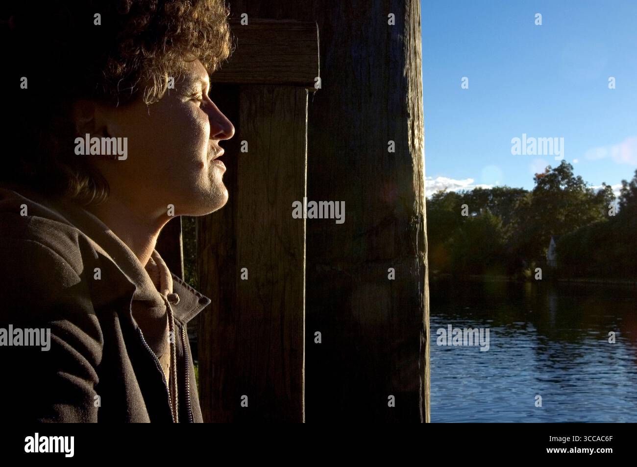 Portrait d'une jeune femme au soleil de l'après-midi les yeux fermés. Banque D'Images