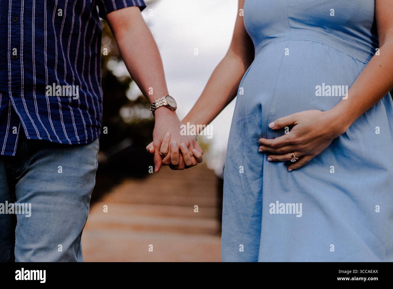 Mari et femme enceinte se tenant la main Banque D'Images