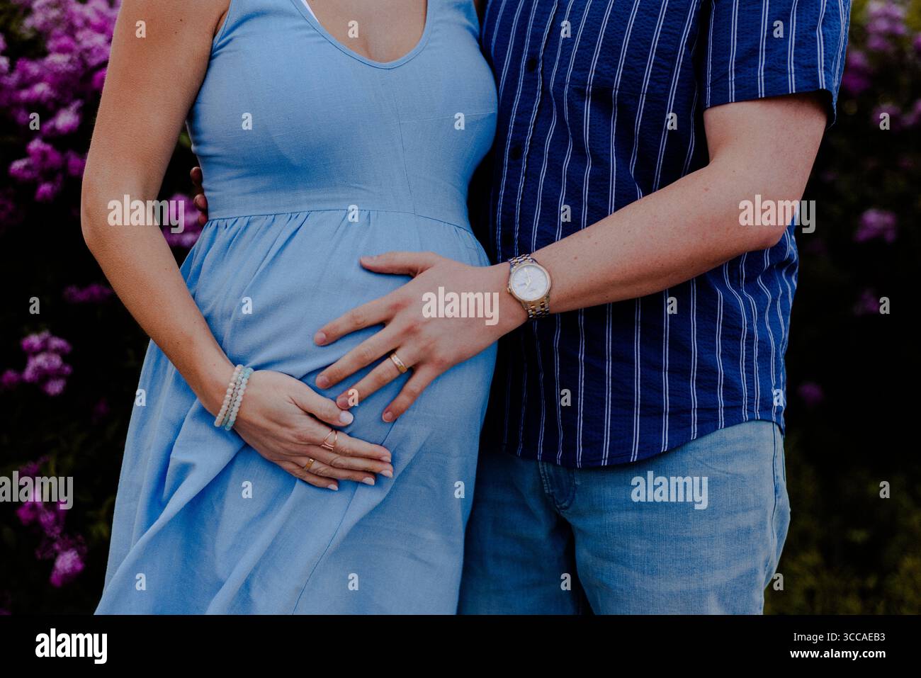 Mari tenant la bosse du bébé de sa femme dans le parc Banque D'Images