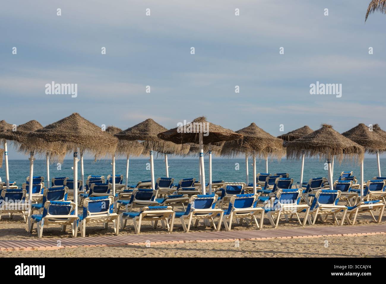 Chaises longues vides sur la plage Playa de Burriana Banque D'Images