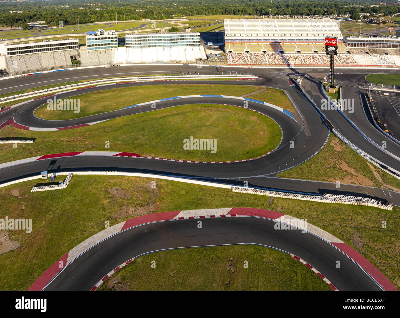 Concord, États-Unis - 28 juillet 2025 : vue aérienne du circuit animé du Charlotte Motor Speedway, avec ses barrières blanches et rouges frappantes contrastant avec l'intérieur vert luxuriant. Banque D'Images