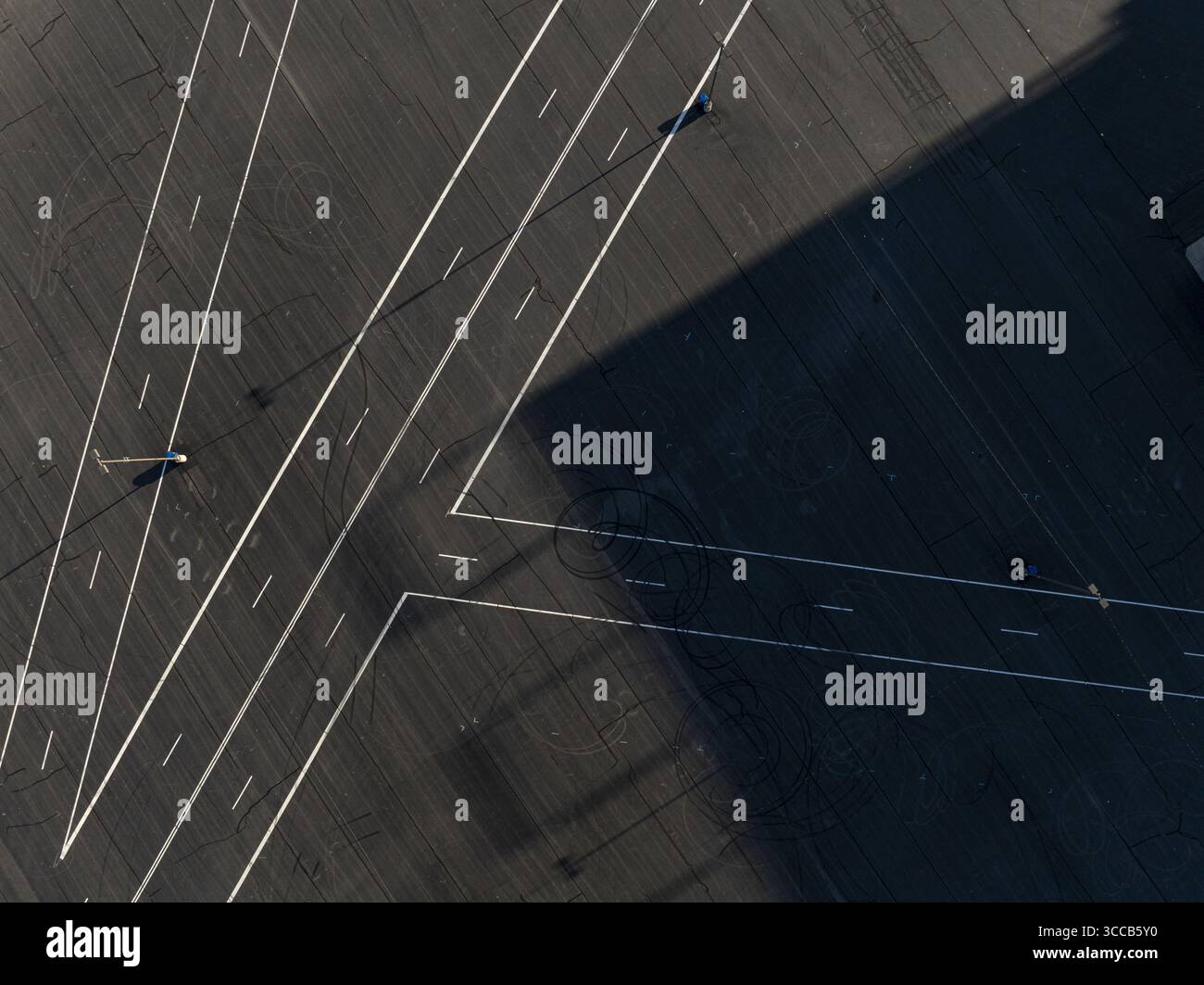 Concord, États-Unis - 28 juillet 2025 : vue aérienne des lignes blanches et pures qui disséquent l'asphalte sombre, créant des motifs géométriques sous les longues ombres du Charlotte Motor Speedway. Banque D'Images