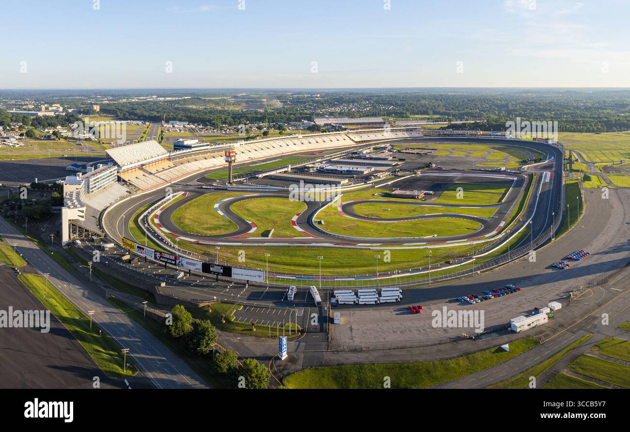 Concord, États-Unis - 28 juillet 2025 : vue aérienne du Charlotte Motor Speedway avec son circuit sinueux, ses tribunes baignées de soleil et le paysage urbain environnant. Banque D'Images