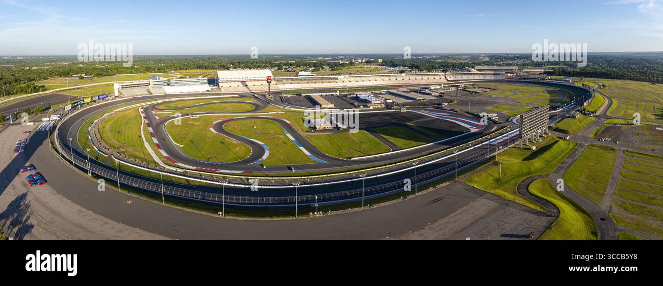 Concord, États-Unis - 28 juillet 2025 : vue aérienne des vastes pistes asphaltées et des champs verts luxuriants du Charlotte Motor Speedway sous un ciel bleu clair. Banque D'Images