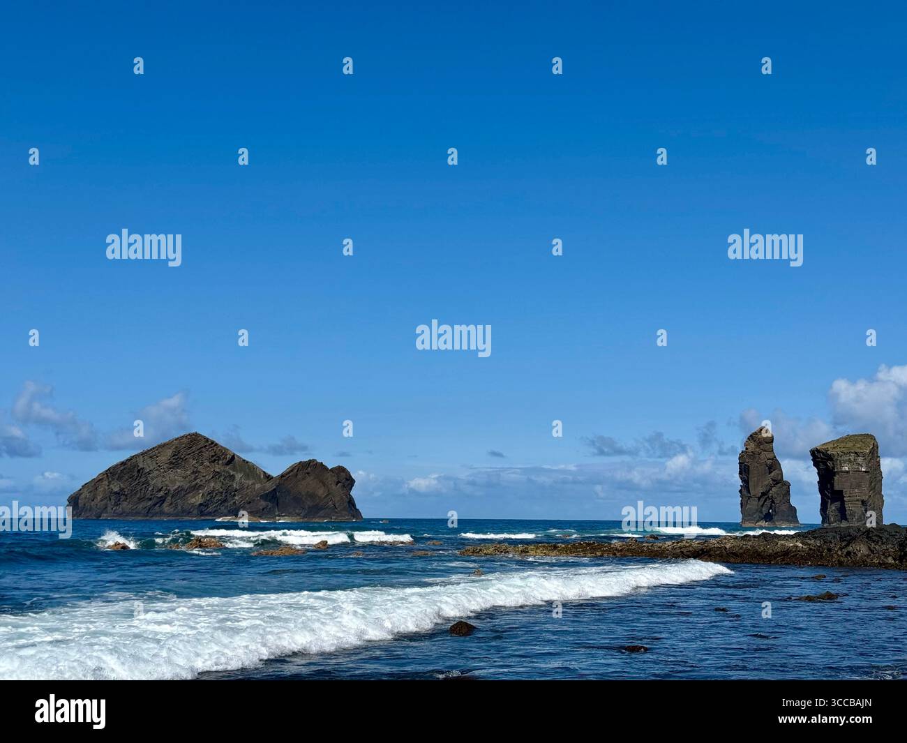 Îlots volcaniques emblématiques de Mosteiros aux Açores, Portugal, s'élevant de l'océan Atlantique sous un ciel bleu clair. Banque D'Images