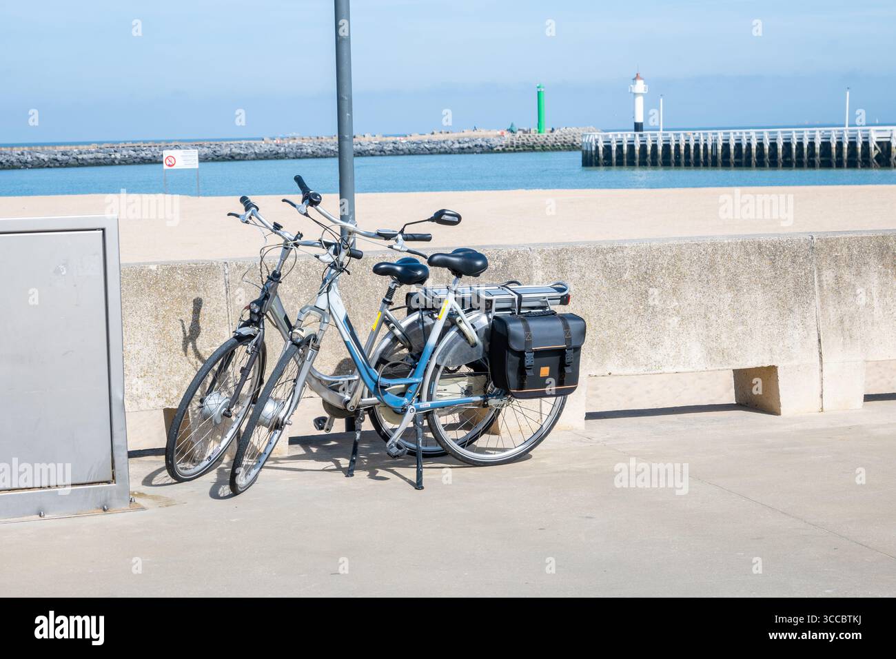 Vélos vintage adultes et enfants dans la rue près de la plage de la mer. Mer bleue, sable jaune et ciel d'été. Vélo pour le sport ou le voyage. Banque D'Images