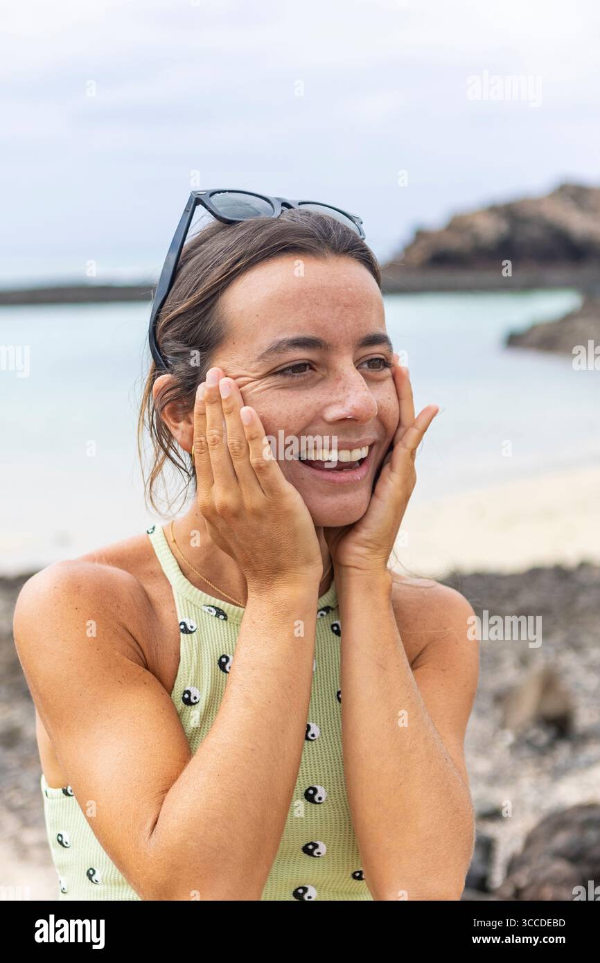 Femme insouciante avec des lunettes de soleil sur sa tête profite de ses vacances à la plage Banque D'Images