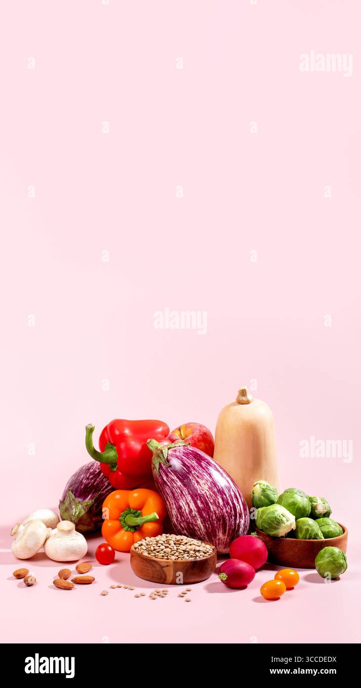Carte végétalienne avec des légumes d'automne frais de saison, nature morte végétalienne d'automne sur rose, espace de copie Banque D'Images