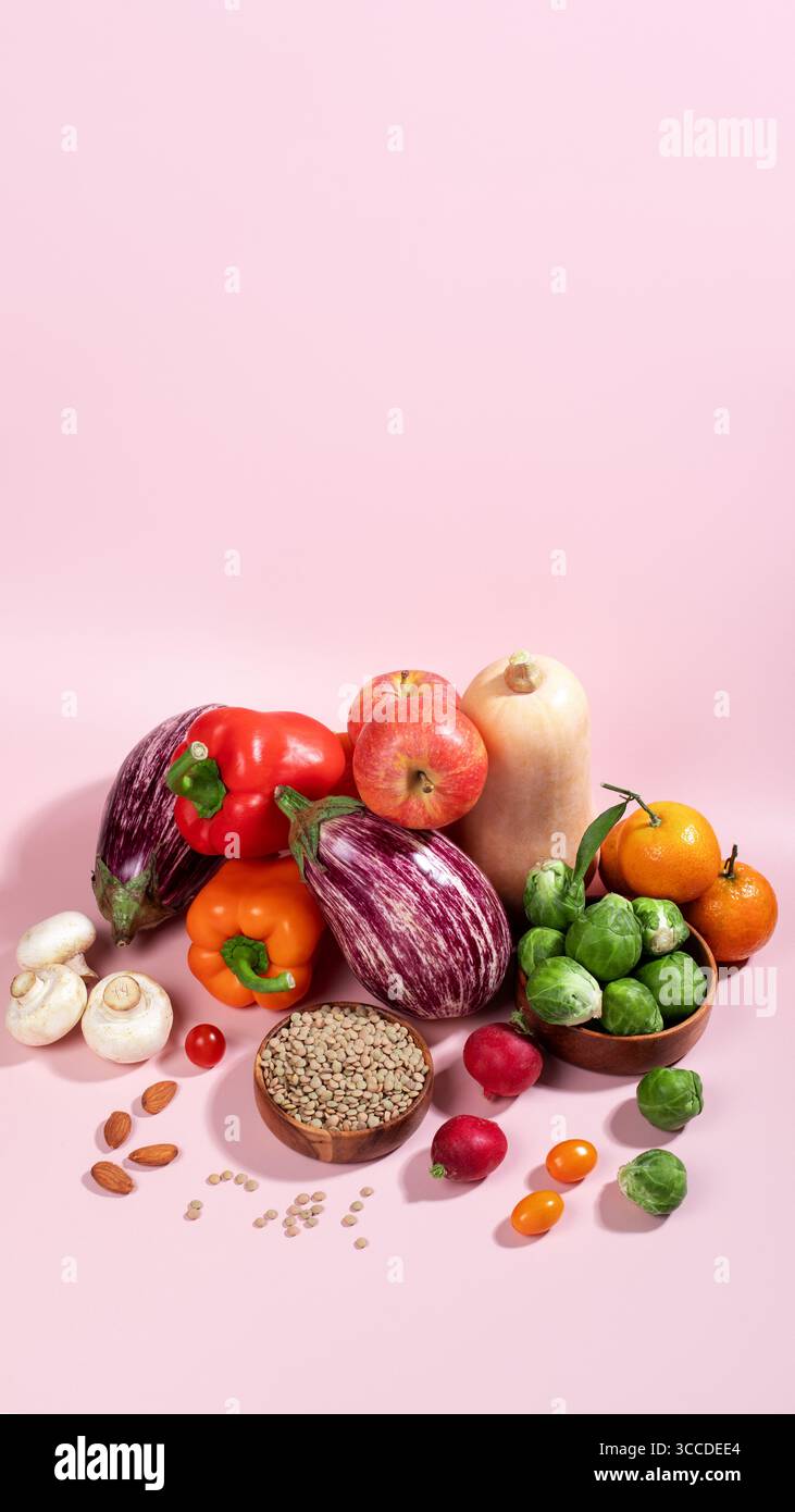 Carte végétalienne avec des légumes d'automne frais de saison, nature morte végétalienne d'automne sur rose, espace de copie Banque D'Images