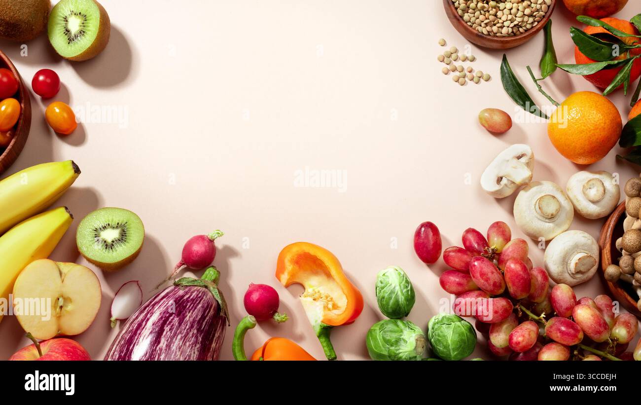 Cadre fait de fruits, de légumes et d'un bol de lentilles, plat d'alimentation saine repose sur fond beige. vue de dessus, espace de copie Banque D'Images