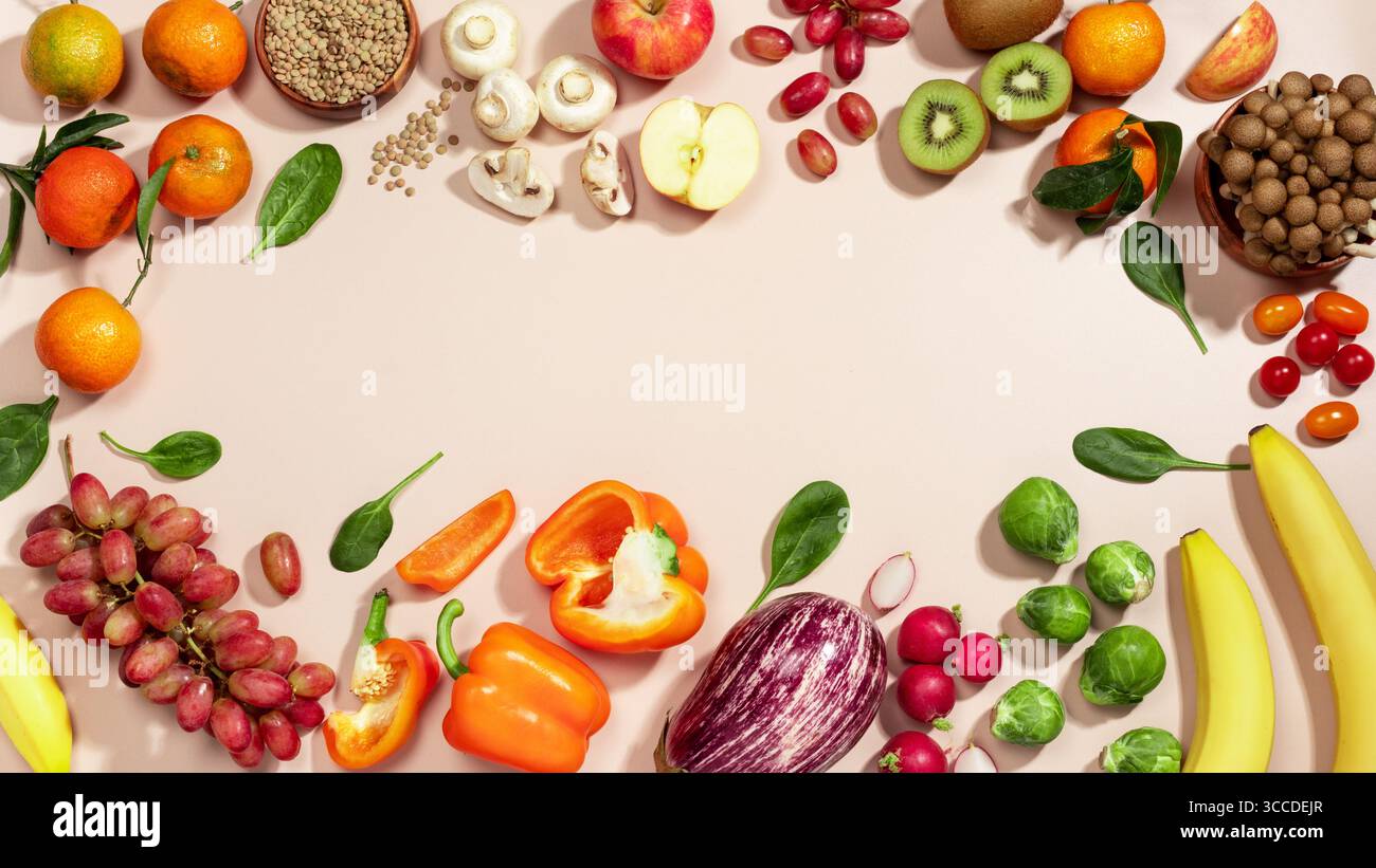 Cadre fait de fruits, de légumes et d'un bol de lentilles, plat d'alimentation saine repose sur fond beige. vue de dessus, espace de copie Banque D'Images
