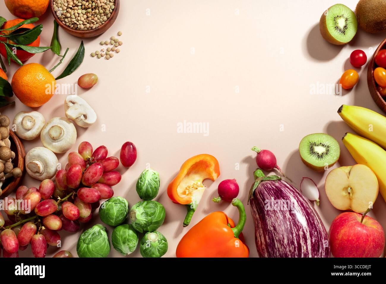 Cadre fait de fruits, de légumes et d'un bol de lentilles, plat d'alimentation saine repose sur fond beige. vue de dessus, espace de copie Banque D'Images