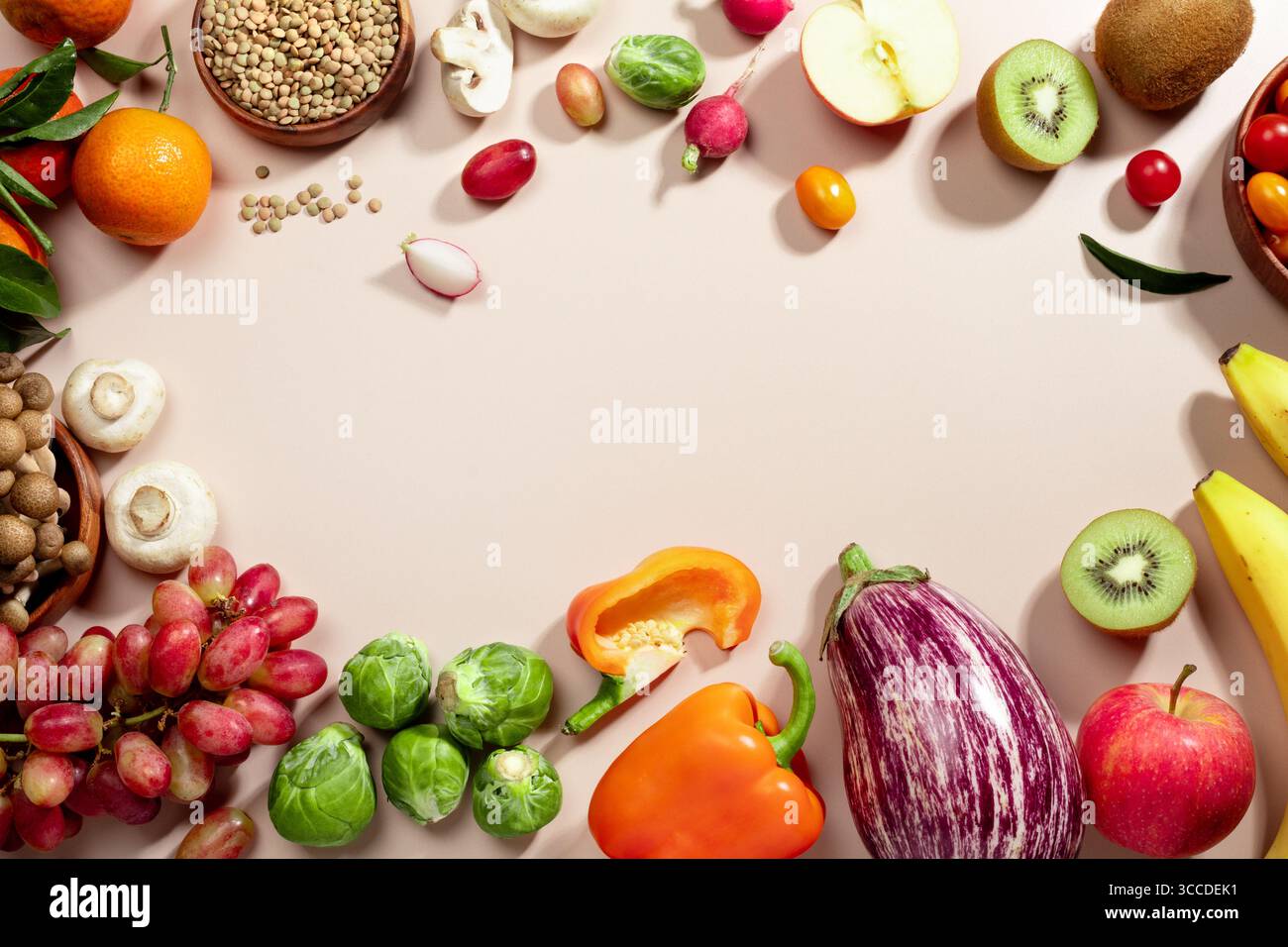 Cadre fait de fruits, de légumes et d'un bol de lentilles, plat d'alimentation saine repose sur fond beige. vue de dessus, espace de copie Banque D'Images