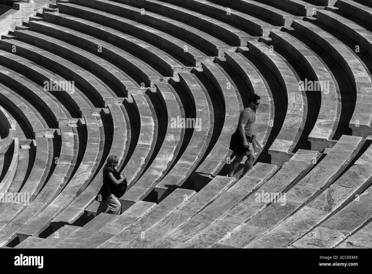 Couple grimpe les marches en marbre du stade panathénaïque historique d'Athènes, en Grèce, profitant de la journée ensoleillée et de l'architecture emblématique Banque D'Images