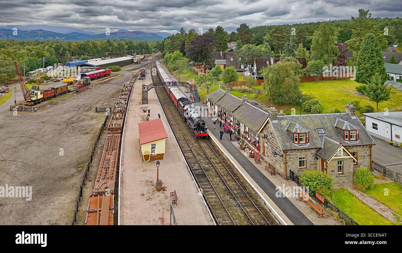 Strathspey Railway Boat de Garten Station Scotland le train à vapeur arrivant à la plate-forme et le bâtiment couvert de fleurs Banque D'Images