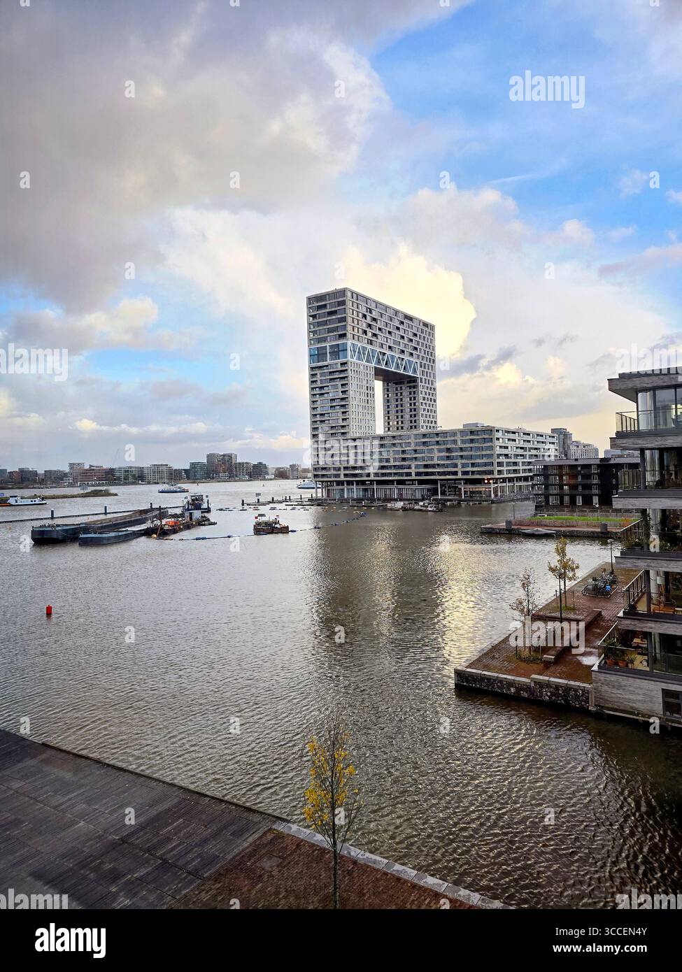 Vue à l'heure d'or d'un canal d'Amsterdam avec une eau calme reflétant des bâtiments historiques et un pont, pays-Bas. - Image de stock capturée avec un smartphone