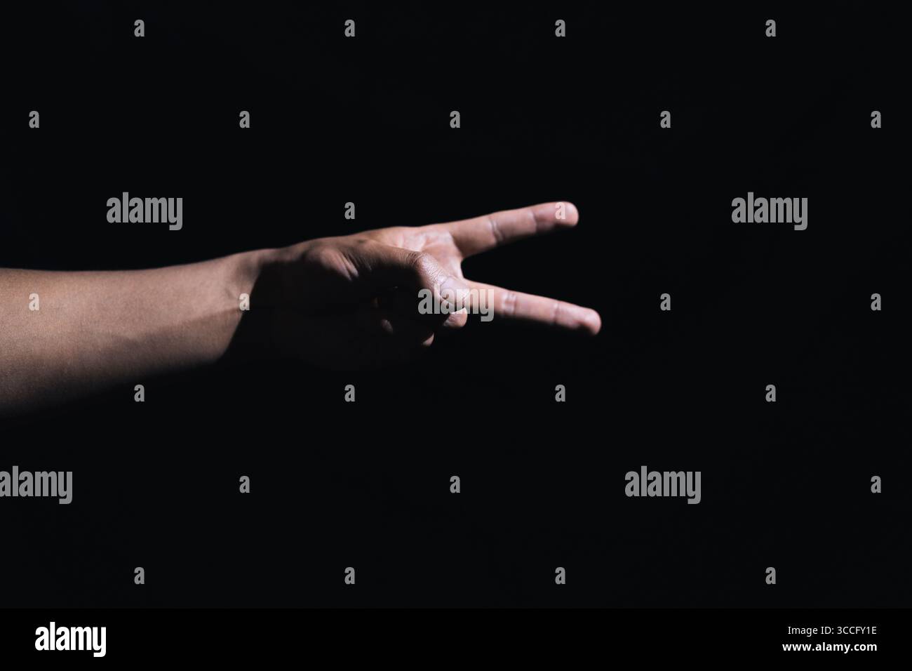 panneaux à main avec un fond noir illuminé par une lumière artificielle Banque D'Images