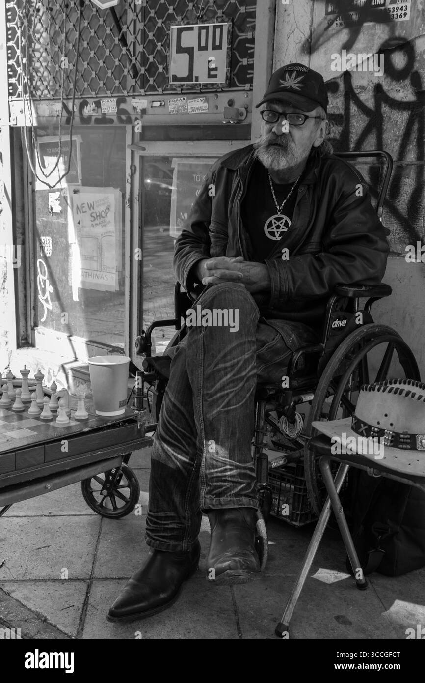 Homme offrant de jouer aux échecs en plein air à Athènes, en Grèce, scène de rue de banlieue avec la culture locale, les loisirs traditionnels et le style de vie grec quotidien Banque D'Images