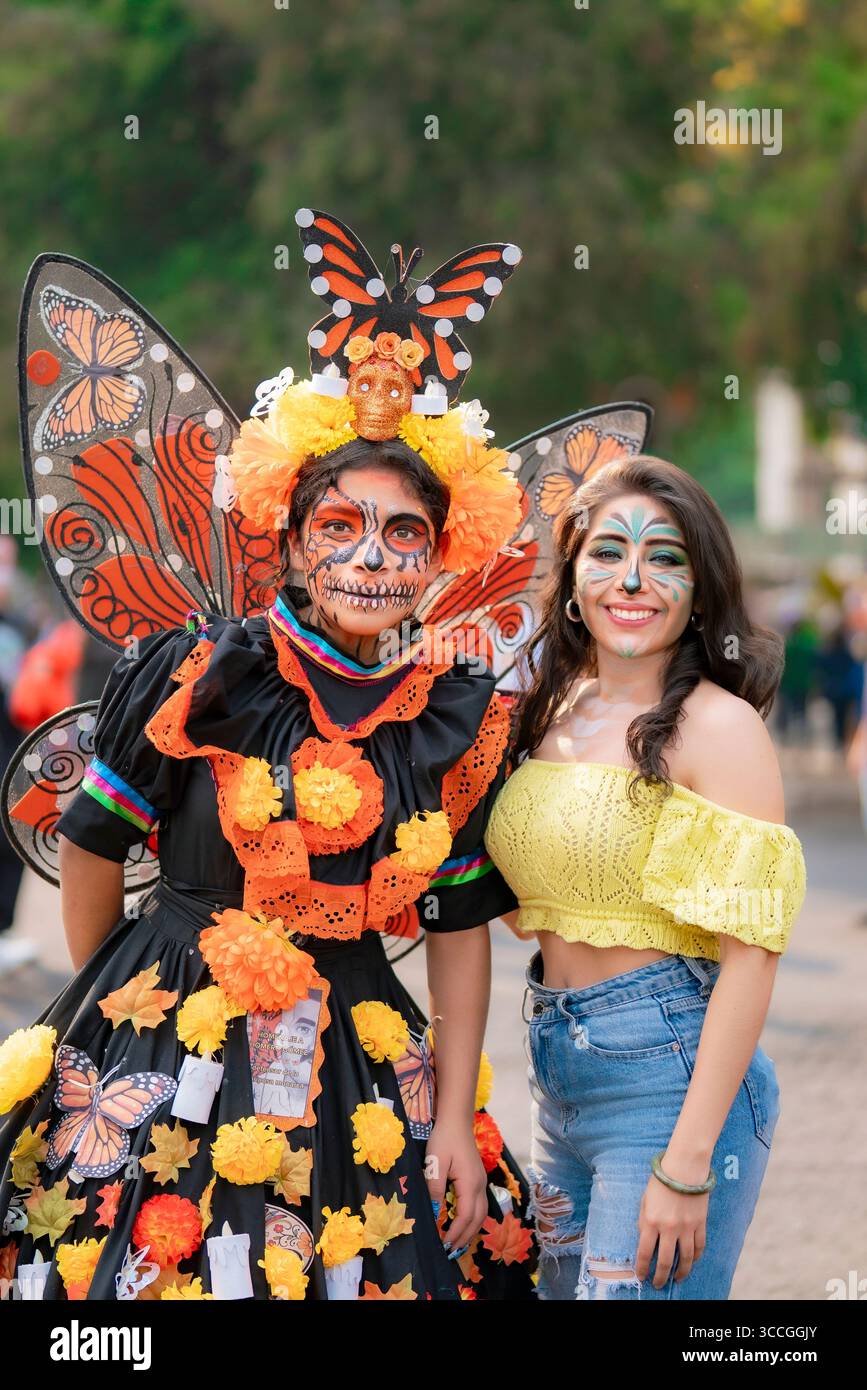Mexico, Mexique - 2 novembre 2024 : deux Latinas sourient pendant le défilé de Dia de Muertos sur Reforma. On porte des ailes de papillon, du cempasuchil et du crâne ma Banque D'Images