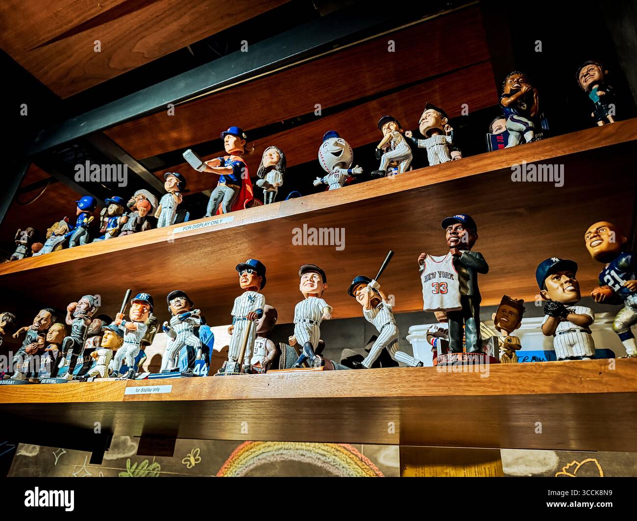 Une collection de bobbleheads de stars du sport au-dessus du bar d'un restaurant à New York Banque D'Images