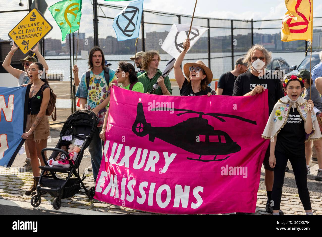 13 septembre 2023, New York, New York, États-Unis : des activistes de extinction Rebellion NYC manifestent à l'héliport JRA West 30th Street ciblant les émissions de luxe telles que les trajets en hélicoptère. Les gens tiennent une bannière qui dit â€œLuxury émissions'' et des drapeaux avec le symbole extinction Rebellion. Une poussette tient des poupées bébé. Les manifestants appellent à la fin des combustibles fossiles et des émissions de carbone inutiles provenant des modes de vie de luxe pour faire face à l’urgence climatique et protéger les générations futures. La manifestation est l'une des nombreuses manifestations organisées par des groupes climatiques en prévision du mas ''Biden : End Fossil Fuels'' Banque D'Images