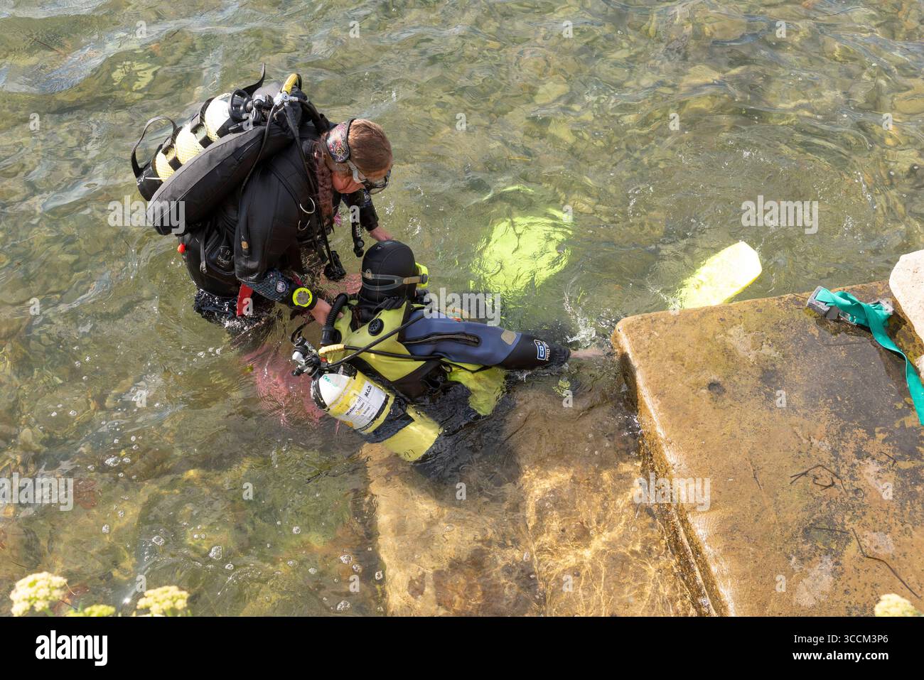 Swanage Dorset Angleterre Royaume-Uni. 02.08.2025. Instructeur de plongée assistant un élève de la mer. Banque D'Images