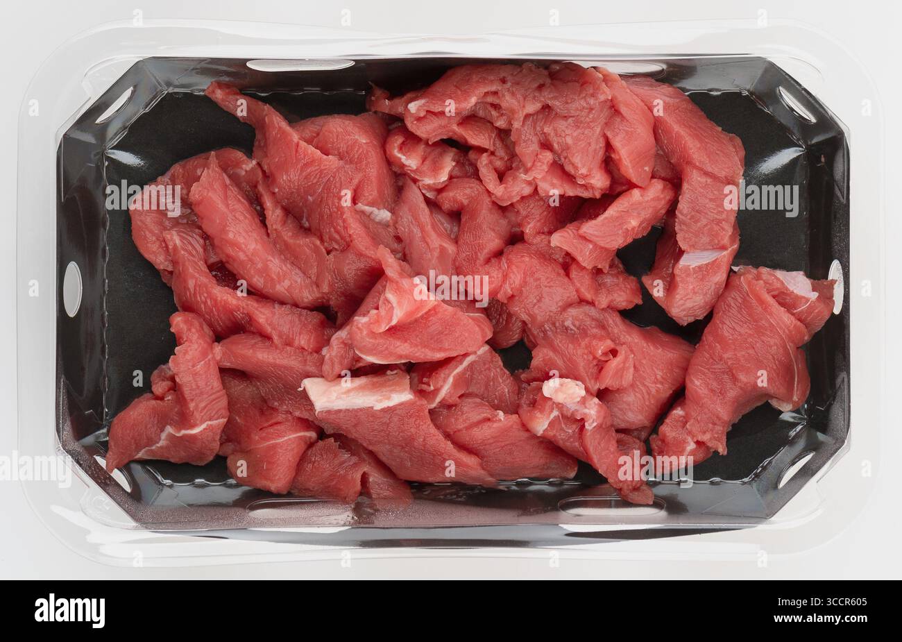 Viande fraîche coupée en morceaux dans la boîte en plastique vue de dessus fond isolé de la nature avec chemin de découpage Banque D'Images