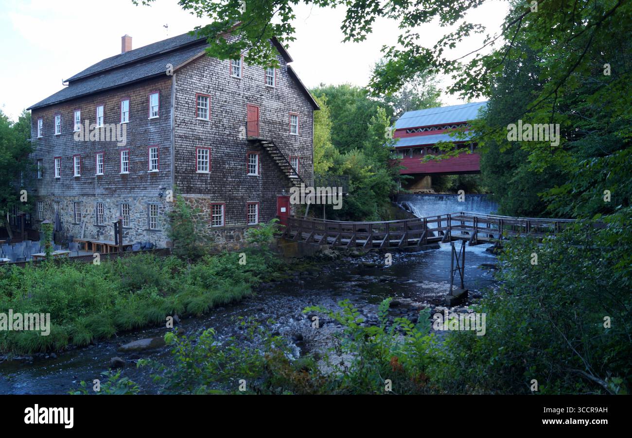 Ulverton Woolen Mill, musée du patrimoine, avec le vieux pont couvert en bois sur le ruisseau, Ulverton, Québec, Canada Banque D'Images