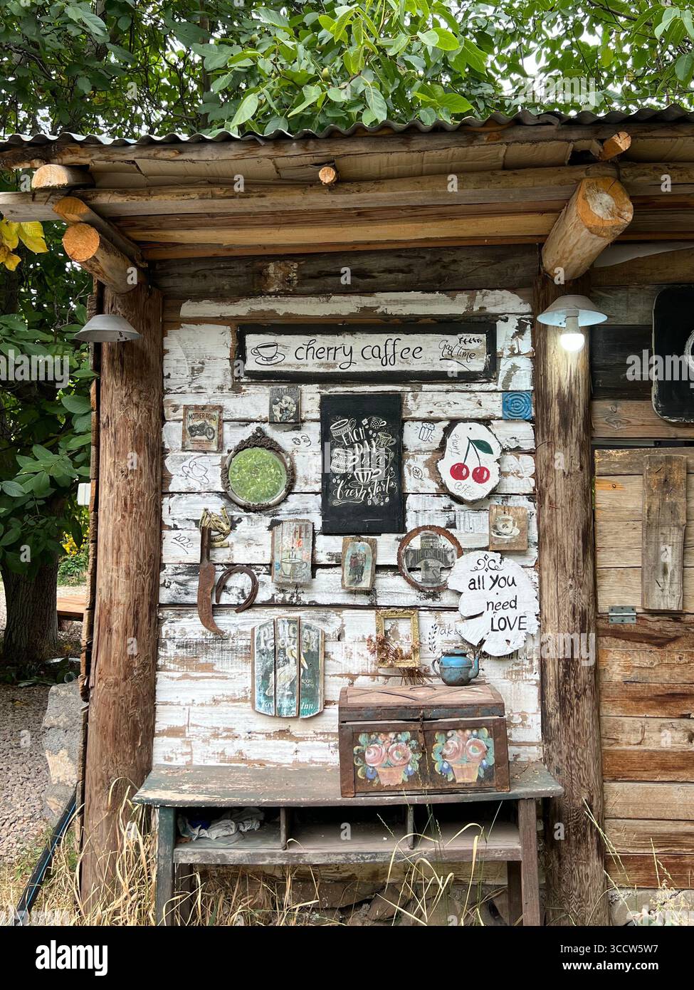 Coin café extérieur rustique avec des signes vintage et des textures en bois, créant une atmosphère de campagne confortable. Banque D'Images