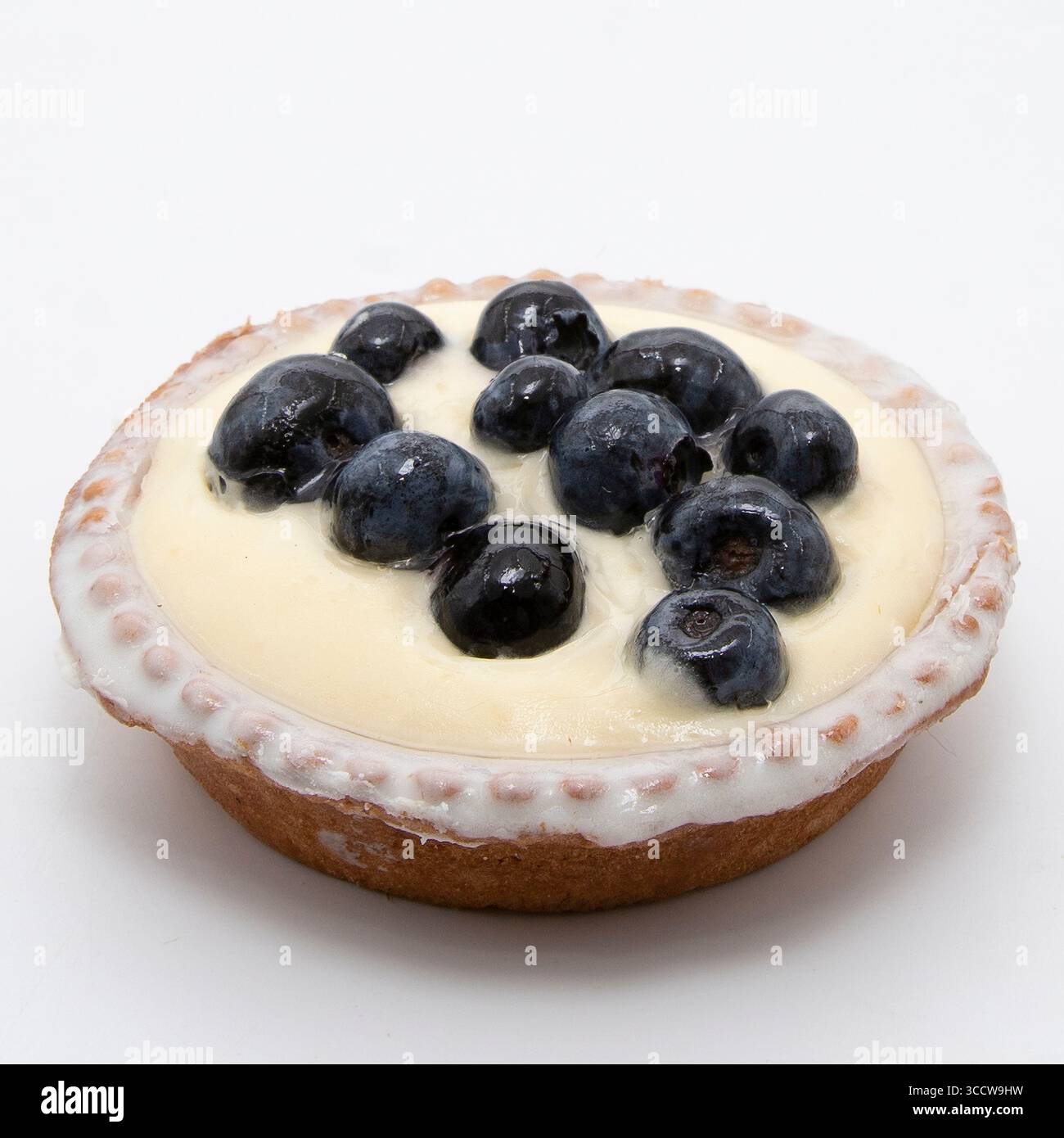 Délicieuse tarte aux myrtilles avec une garniture crémeuse sur fond blanc parfaite pour les menus de desserts et la photographie culinaire Banque D'Images