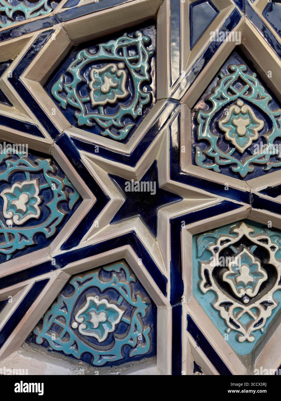 Vue détaillée de la mosaïque ornementale islamique avec des motifs géométriques en forme d'étoile et des motifs floraux dans les couleurs turquoise et bleu marine Banque D'Images