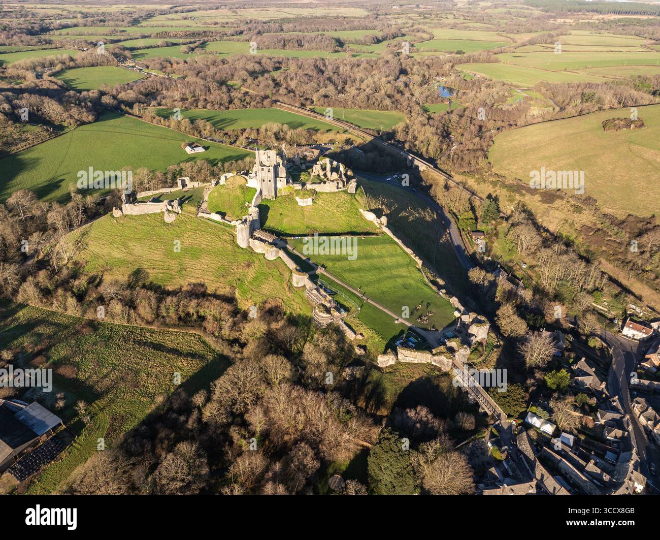 Vue aérienne d'une ancienne ruine de château se trouve au sommet d'une colline herbeuse, entourée de champs verdoyants et de forêts denses, projetant de longues ombres, Trim, Irlande. Banque D'Images
