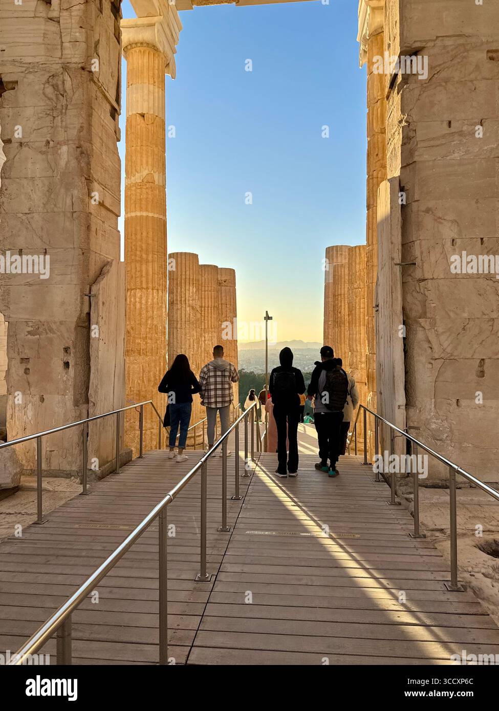 Coucher de soleil heure d'or à l'entrée du complexe de l'Acropole (Acrópole Propileia) à Athènes, Grèce, avec des touristes marchant dans les escaliers. Banque D'Images