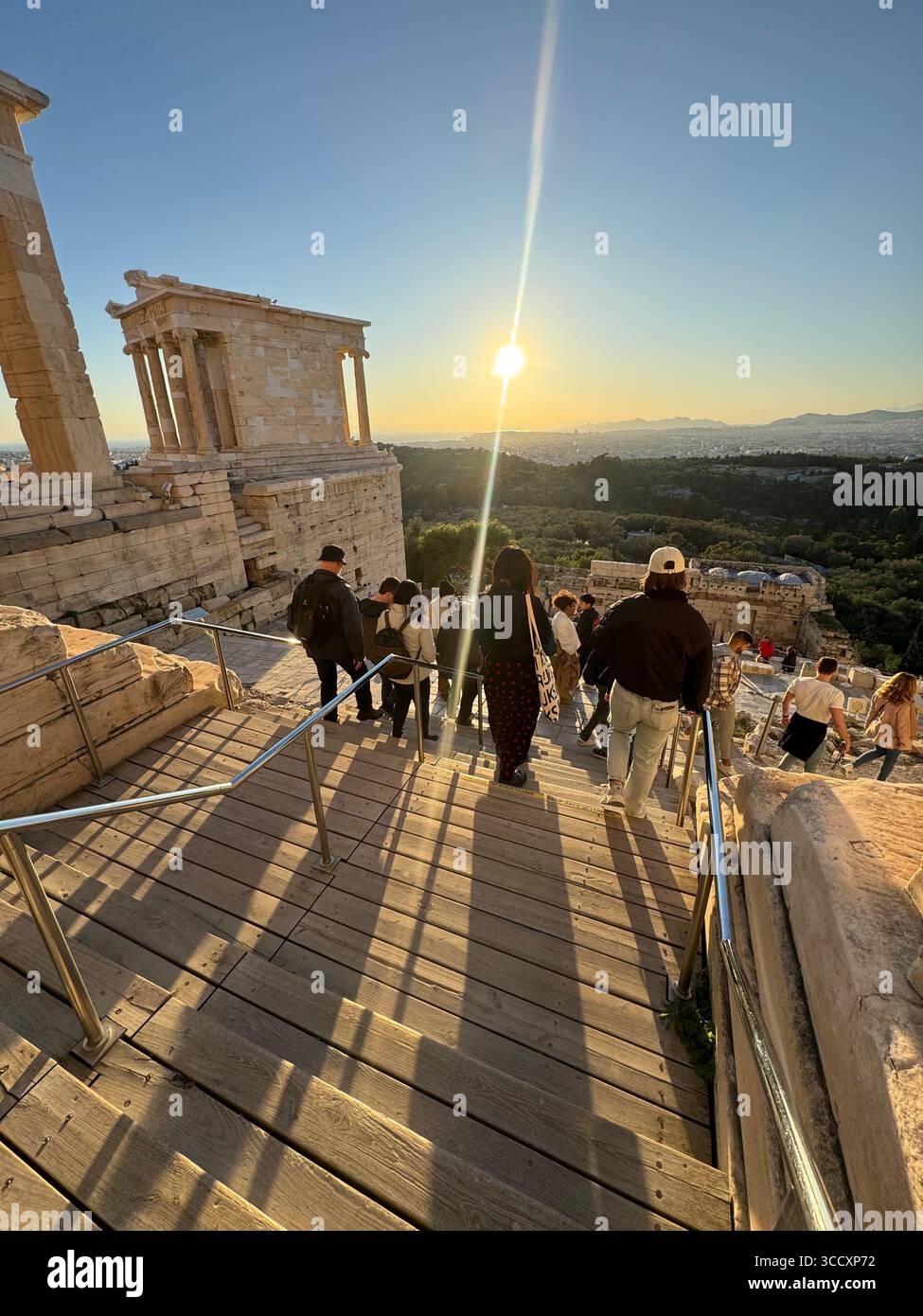 Coucher de soleil heure d'or à l'entrée du complexe de l'Acropole (Acrópole Propileia) à Athènes, Grèce, avec des touristes marchant dans les escaliers. Banque D'Images