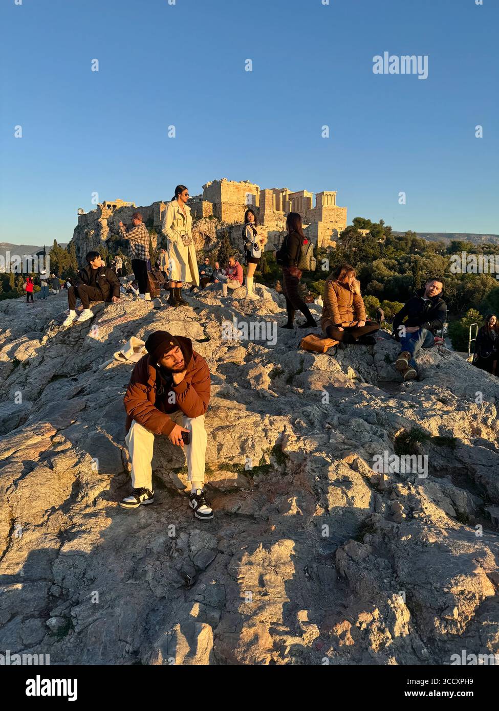 Couleurs de coucher de soleil peignant le ciel au-dessus d'Athènes, vu de la colline d'Aréopage avec l'Acropole et la colline de Lycabette en arrière-plan. - Image de stock capturée avec un smartphone