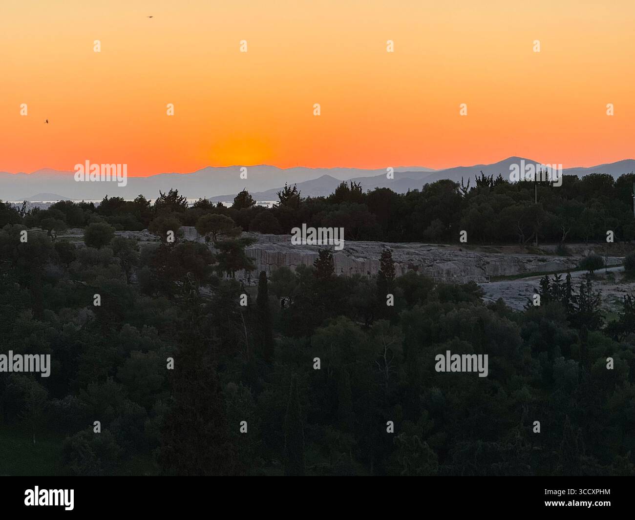 Couleurs de coucher de soleil peignant le ciel au-dessus d'Athènes, vu de la colline d'Aréopage avec l'Acropole et la colline de Lycabette en arrière-plan. - Image de stock capturée avec un smartphone