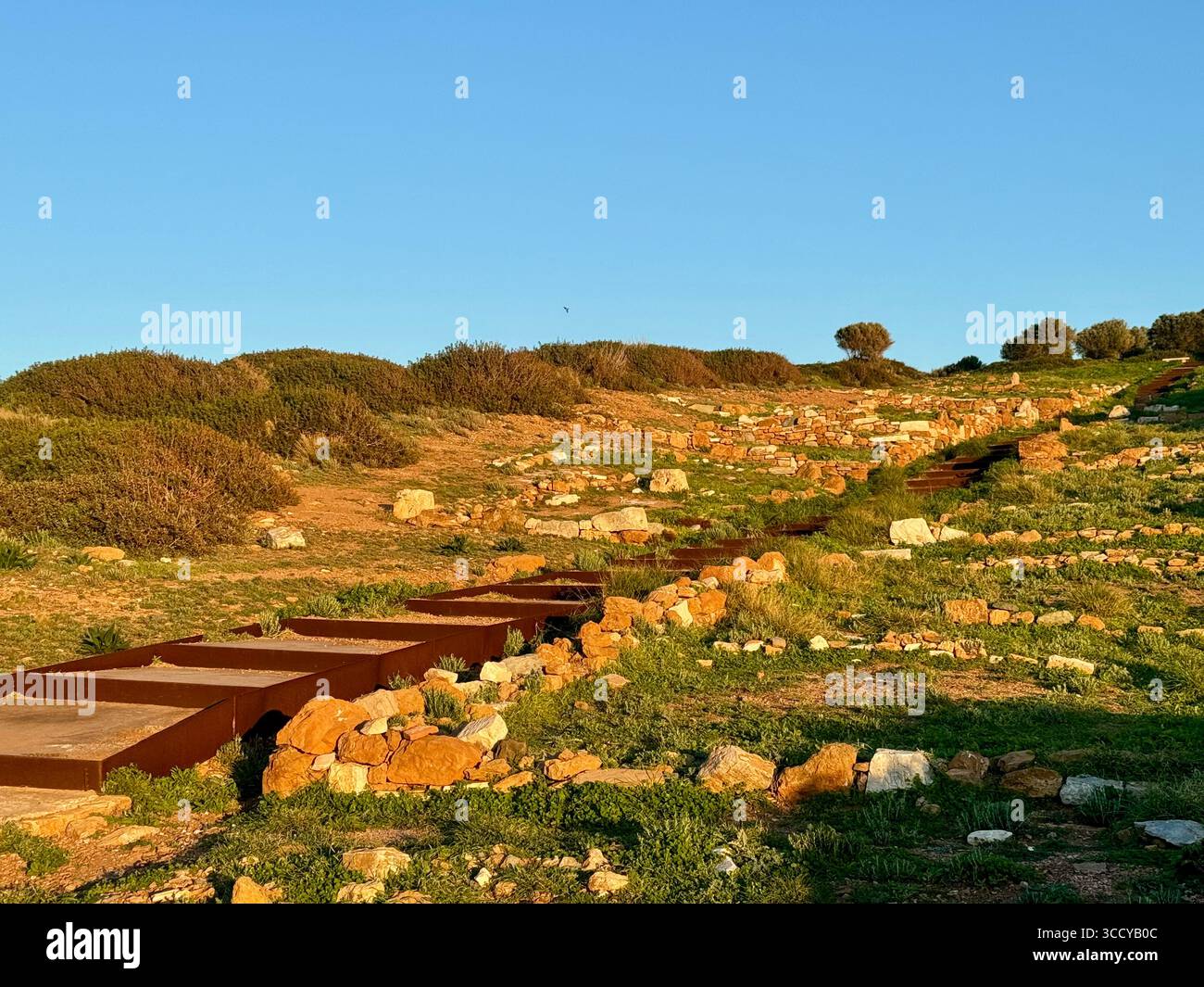 La lumière de l'heure d'or baigne le site archéologique de Sounion, en Grèce, y compris les sentiers et les ruines près du temple de Poséidon. Banque D'Images
